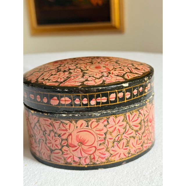 Vintage Kashmiri papier-mâché trinket box hand painted with an intricate floral composition on a dramatic jet-black...