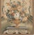 A hand woven floral Chinese tapestry with a floral motif and birds and muted colors.