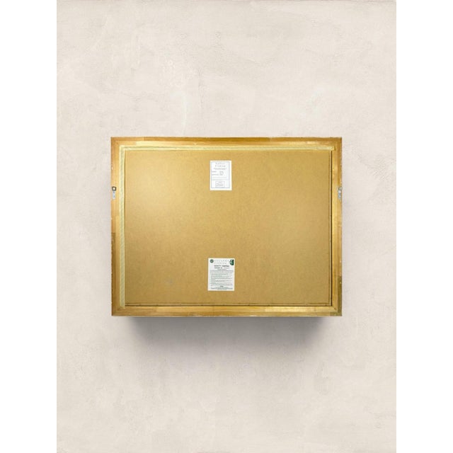 A large vintage English wall mirror, made in England circa 1990, featuring an ornate gilt frame with beautiful carved-...