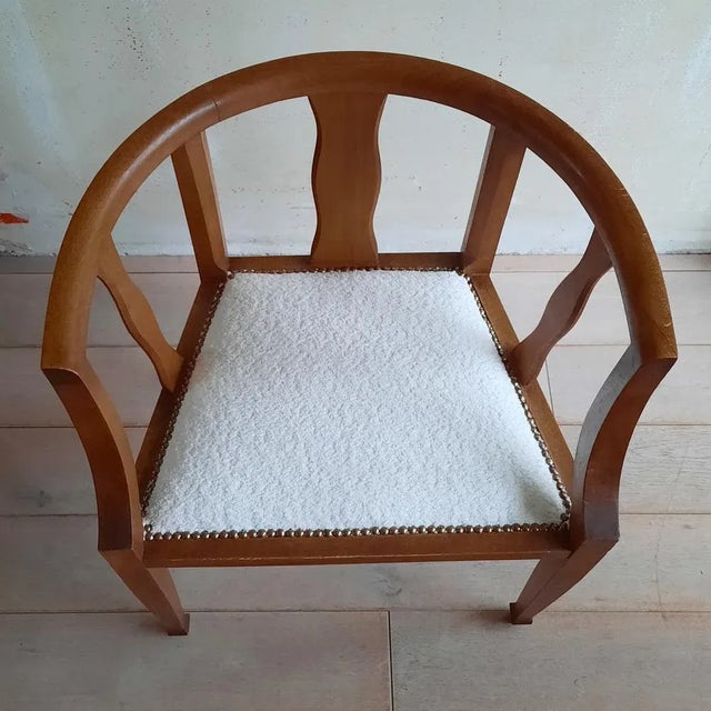 This French art deco chair has been fitted with a new interior, new straps, and an off-white bouclé fabric.