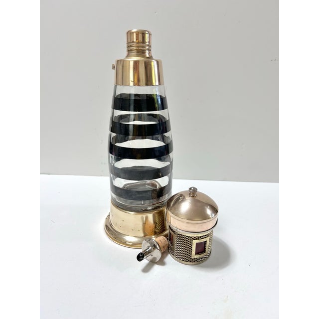 Bring a touch of maritime charm to your bar or library with this striking vintage lighthouse-form cocktail shaker...