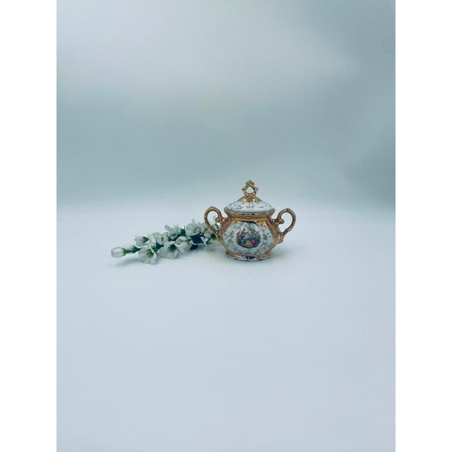 This Italian-made sugar bowl is crafted from high-quality porcelain. It features a fitted lid and two delicately curved...