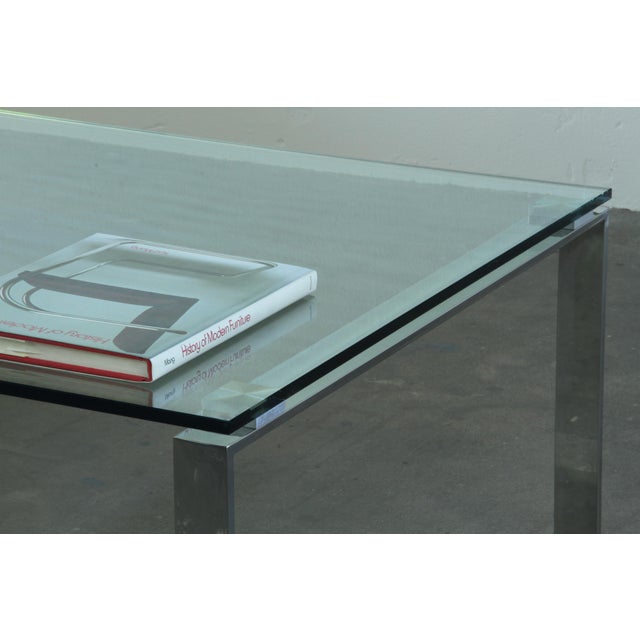 A refined 1990s Danish Modern coffee table in clear glass and polished chrome. The clean rectangular silhouette pairs a...