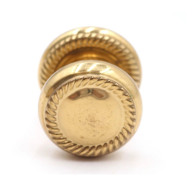 Traditional style round cabinet or drawer knob made of polished brass with a rope design. The original mounting screws are...