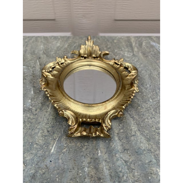 An Italian Rococo–style giltwood wall mirror, richly carved with scrolling acanthus and shell motifs that give the piece...