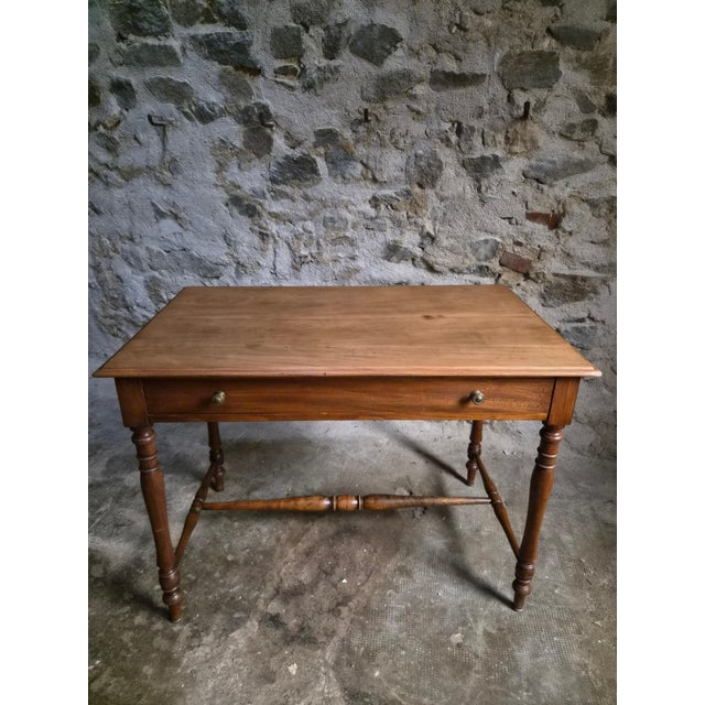 Elm table from France, dating from the 1920s. It has a rectangular top with a moulded edge, turned legs and connecting...