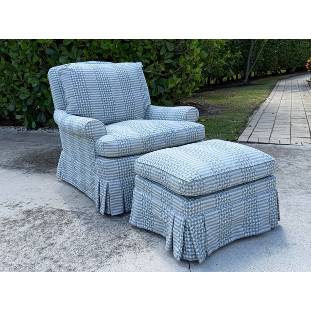 Striking vintage lounge chair and ottoman featuring a traditional skirted silhouette, blue and white checked upholstery,...
