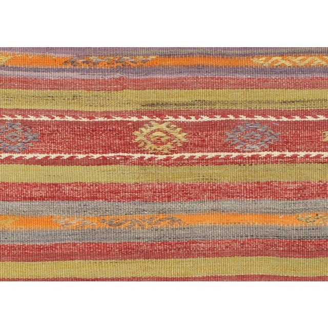 This vintage Turkish Kilim, measuring 3'8" by 5'2", is handwoven with wool on a wool foundation in the Oushak region of...