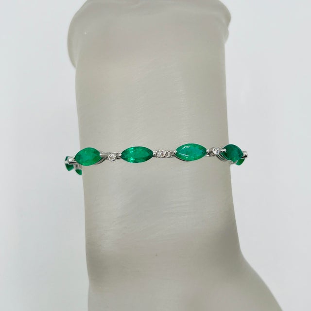 Beautiful 8.20 ct. emerald marquise with 0.10 ct. white diamond rounds. Handmade in 18k white gold. Length is 7".
