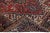 Beautiful antique Heriz hand-knotted wool rug with a red field. This Heriz rug has a dark blue frame and multi-color...