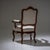 Louis XV style armchair with gilt Rococo-inspired bronze rocaille motifs along the frame. The chair is upholstered in a...