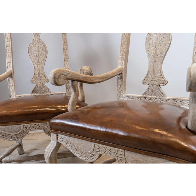 Versatile pair of bleached oak Swedish Carvers or side chairs. They have scroll arms and have decorative carving to the...