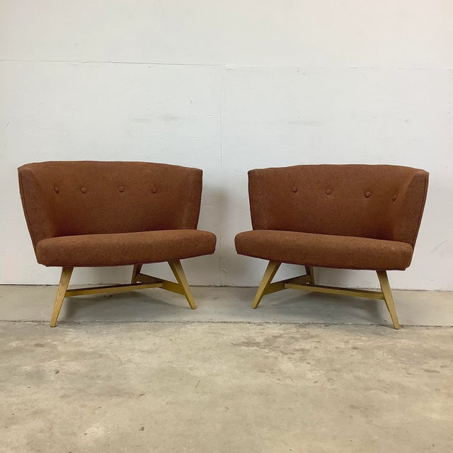 This impressive pair of matching mid-century modern lounge chairs feature rounded barrel like seat backs with vintage...