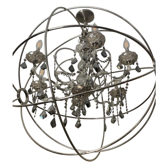 Extraordinary Swedish design of an old world crystal chandelier encased in a modern sphere of metal circles designed in...