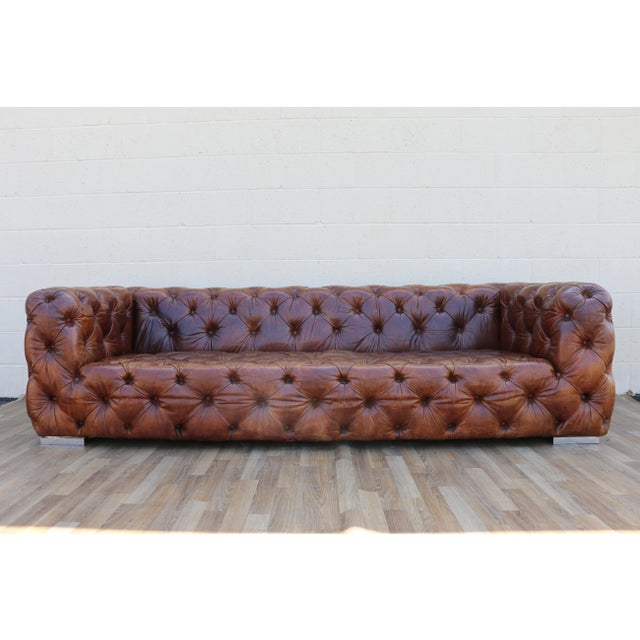 A stunning vintage Chesterfield-style sofa upholstered in rich distressed brown leather, manufactured by Restoration...