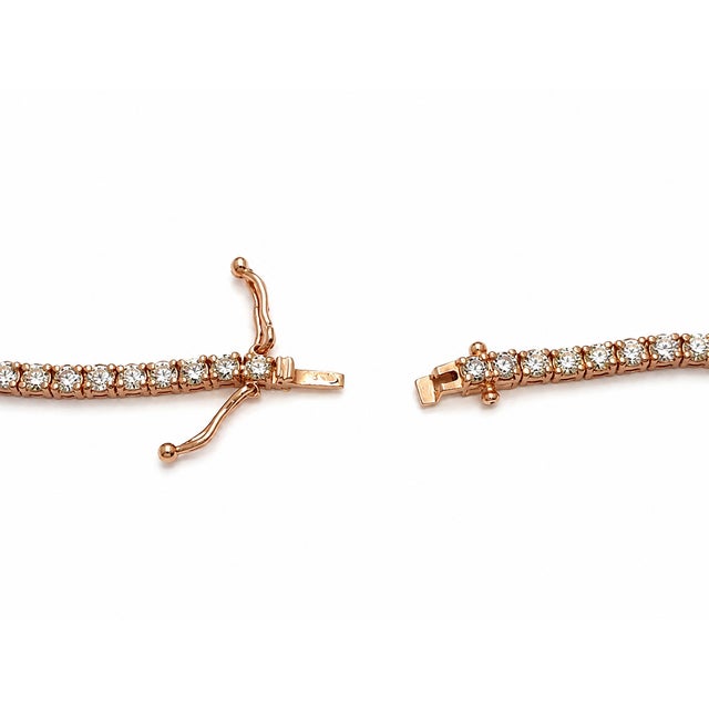 A classic and elegant tennis necklace crafted in 10K rose gold and set with 7 3/8 carats total weight of natural round...