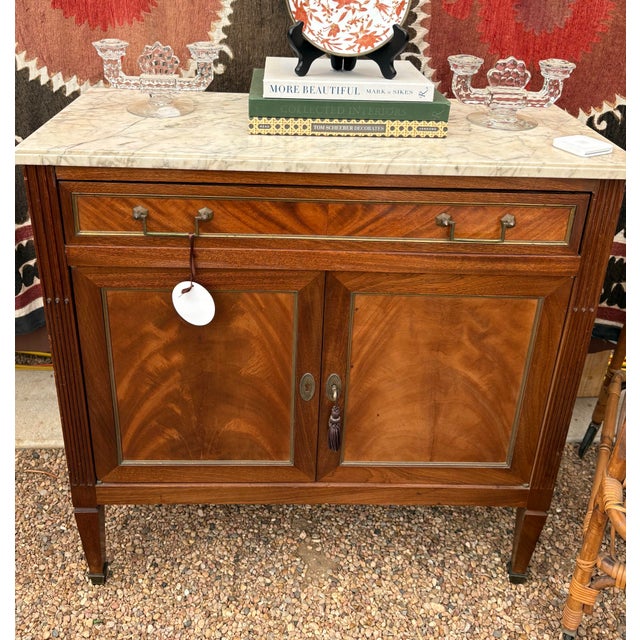 French Louis XVI style flame mahogany sideboard or buffet, early 20th c., having marble top with molded edge, case fitted...