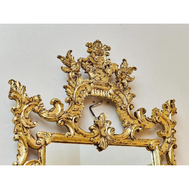 A beautiful carved mirror in the louis xv style. This masterpiece is made of solid wood and richly decorated with hand...