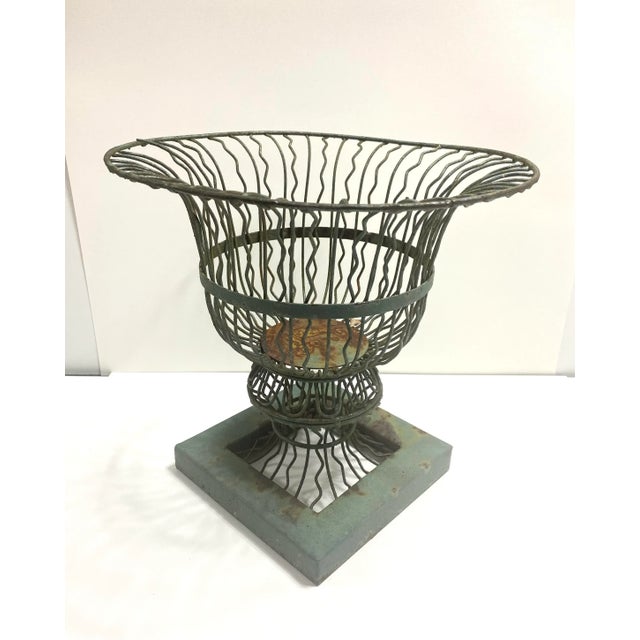 An elegant Victorian-style wire planter featuring an airy sculptural silhouette with a wide flared top and geometric...