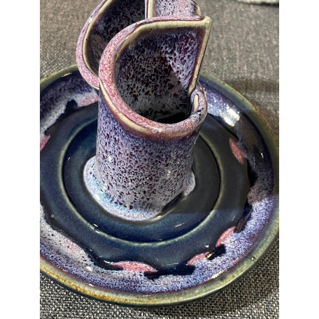 Signed Bay Pottery sculptural ceramic candlestick holder featuring a striking reactive glaze in shades of purple, blue,...