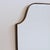 One of two identical vintage Italian wall mirrors with a brass frame (circa 1960s). The mirror is crest-shaped—classically...