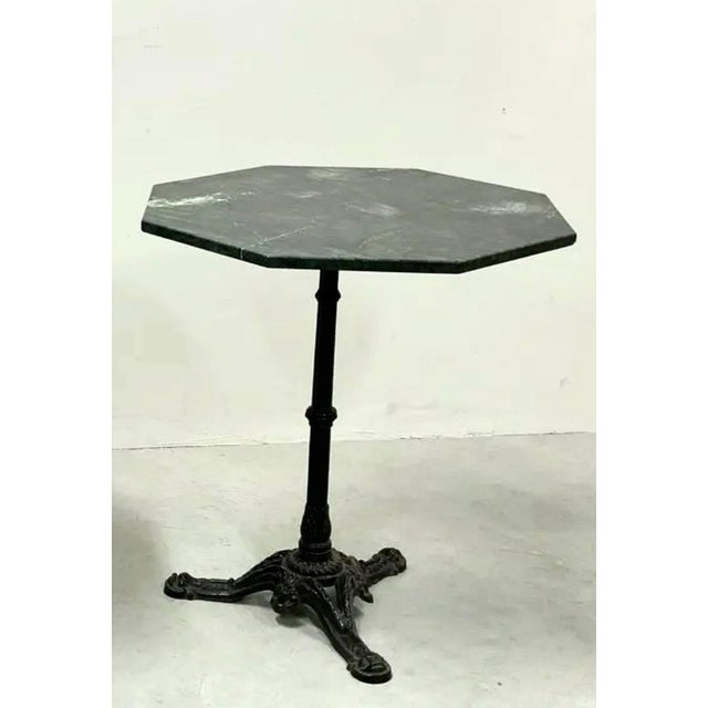 Beautiful Italian dark green marble bistro table in an octagonal shape from the 1970s. Heavy black cast iron pedestal...
