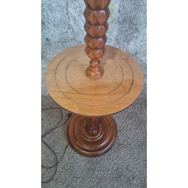 A louis xiii style turned and carved wooden floor lamp, incorporating a round shelf at mid-height. The stem is decorated...