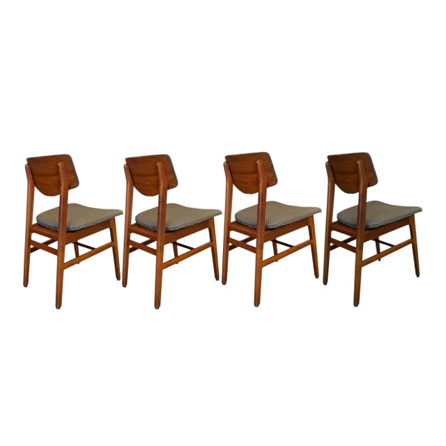 A set of four stylish side chairs by Gunlocke in walnut solids with back panels in wolnut veneers. With a sleek profile,...