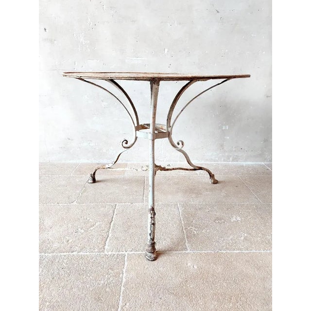 Antique Grassin à Arras garden table made of wrought iron with cast iron feet, with original weathered white-gray patina....