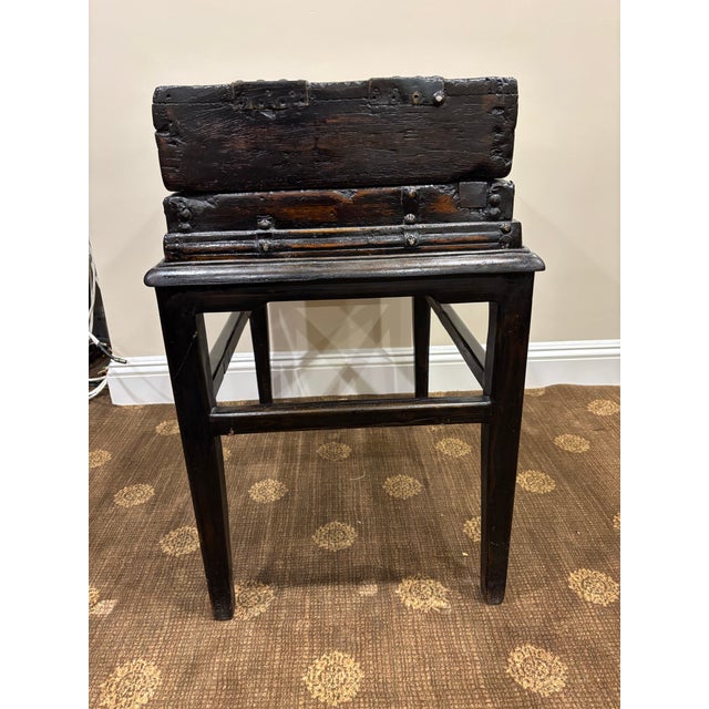 This rustic side table conceals a space for storage when the top is removed. It is fitted with black metal straps and...