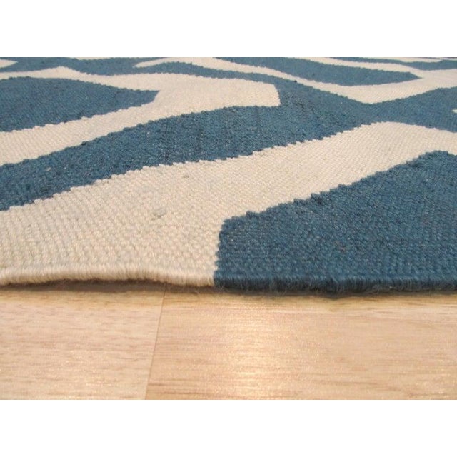 This 5 x 8 area rug is a flat weave polyester Kilim designed for contemporary residential spaces. The primary color...
