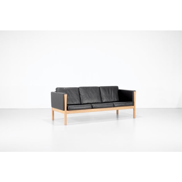 Three-seater sofa, model "ch163," in brown leather, with a solid oak frame and refined details. designed by hans j. Wegner...