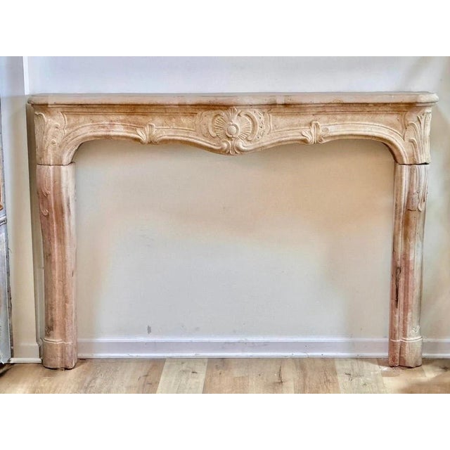 Fine French Limestone Mantelpiece, 18th Century, c, 1745, The serpentine top centered by a rocaille cartouche and scroll...