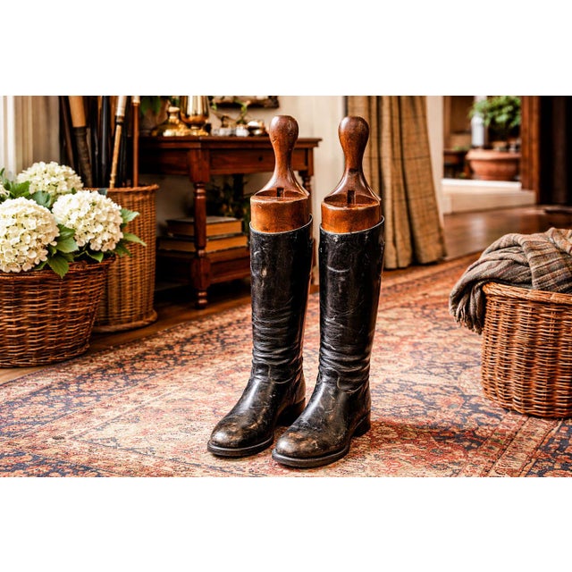 A striking and character-filled pair of antique English horse riding boots, dating to around 1900, these tall black...