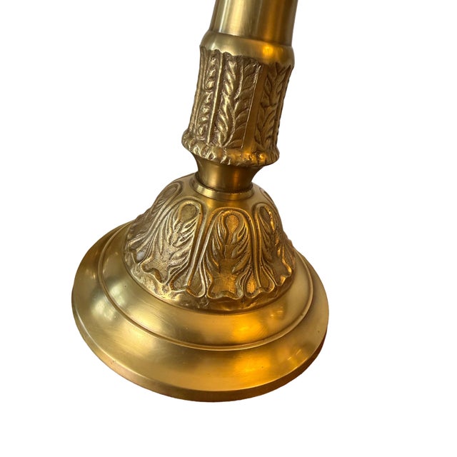 A beautifully crafted pair of vintage brass candle holders featuring scalloped, floral‑form tops designed to hold...