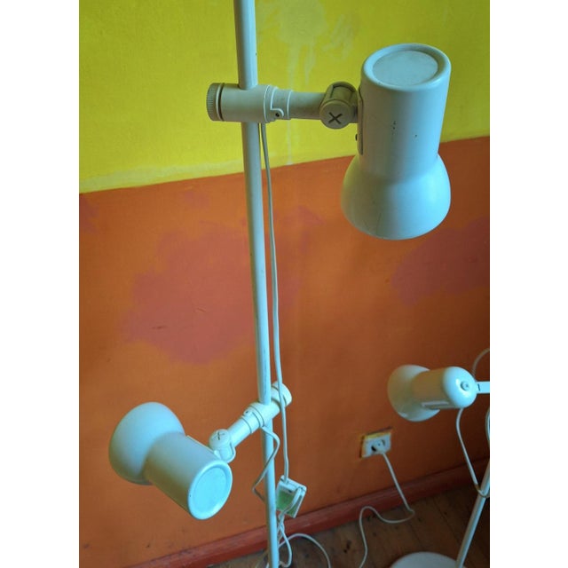 Set of 2 elegant Italian white floor lamps from about 1970 with two spotlight heads that can be raised and lowered and...