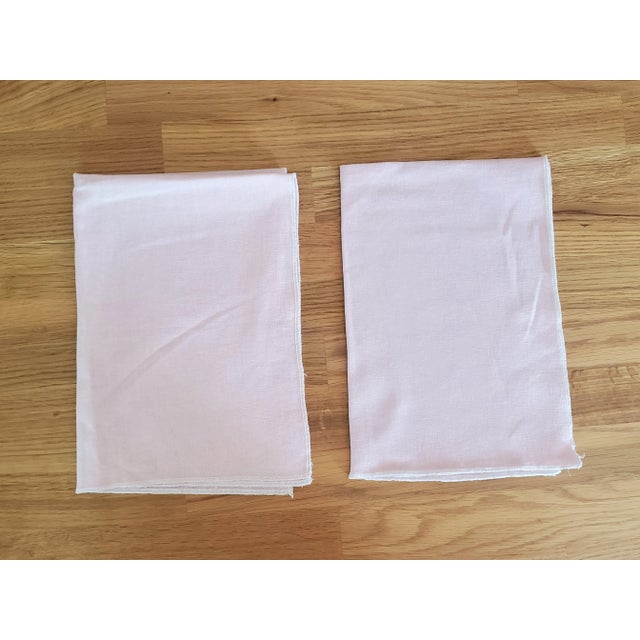 This pair of tea towels, kitchen towels, or dish towels are made of an apparel weight linen in light pink. The edge is...