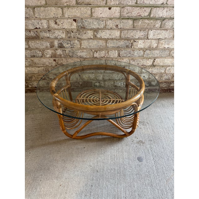 Mid-Century Italian two-tier round coffee table made of curved bamboo, rattan and hand-woven wicker with a glass top....