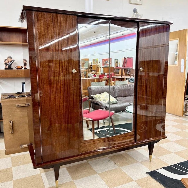 Vintage mid-century French modern or art deco armoire manufactured in France, c.1950s. This monumental mahogany case piece...