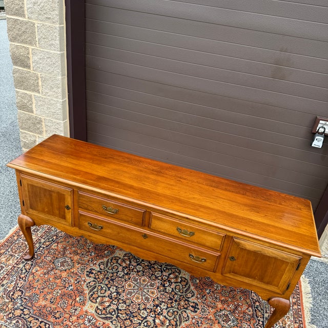 A vintage Statton Queen Anne solid cherry sideboard or buffet having two locking cabinets with three dovetailed drawers in...
