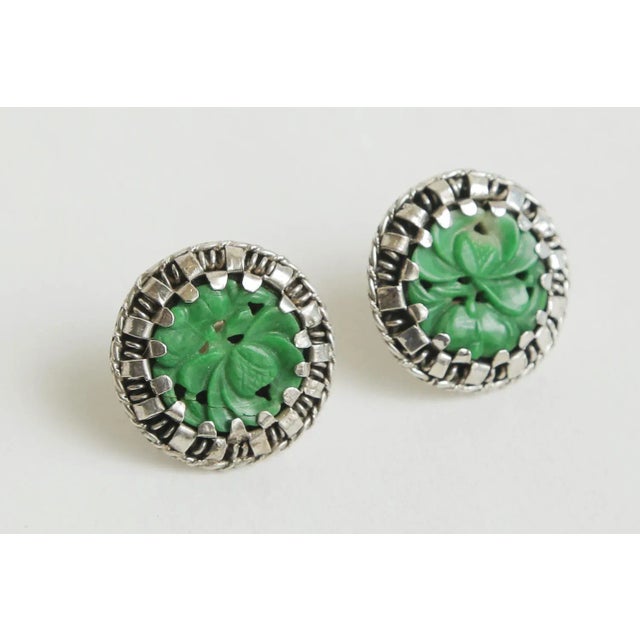This is part of Chairish’s Fine Jewelry assortment. These lovely pierced vintage sterling silver and carved jade earrings...