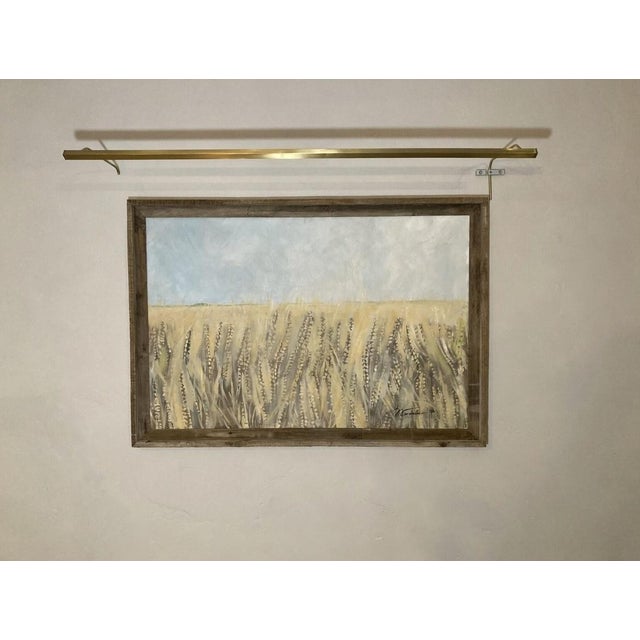 A serene, golden wheat field stretching into the distance under a soft, hazy sky. The foreground emphasizes tall, textured...