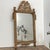 A French Louis XVI period giltwood mirror from circa 1790 with carved crest depicting a gardening theme. This French Louis...