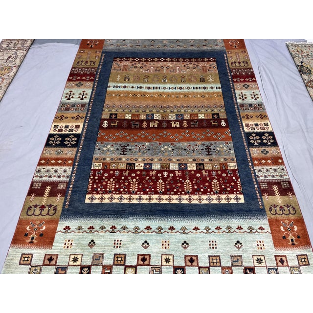 This Afghan Sultani natural dye wool rug features a colorful Khorjin saddlebag-inspired design with horizontal bands of...