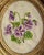 Pretty handmade purple and green floral needlepoint in an oval gold toned frame Please see condition details noted. Most...