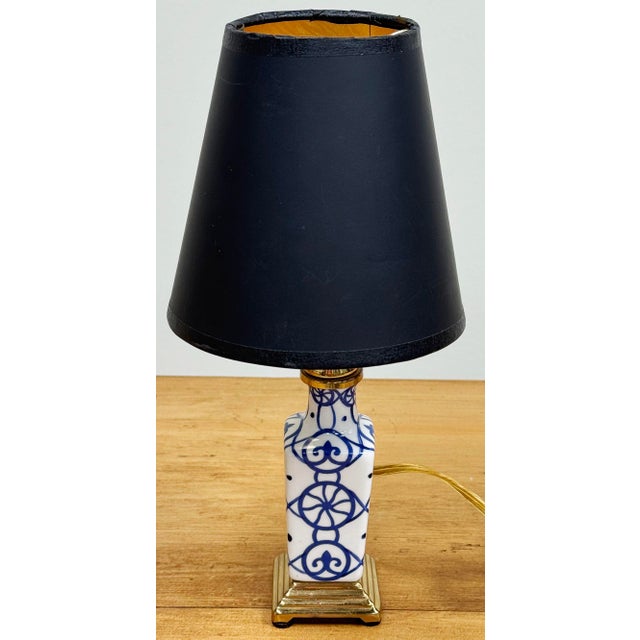 Classic blue and white painted design to ceramic candlestick style body. Mounted on tiered brass base. Measures 10.75" to...