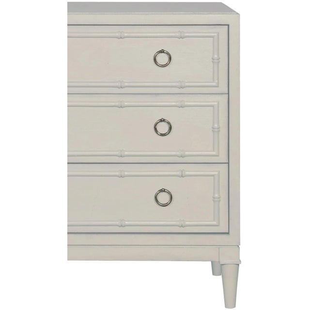 This beautifully detailed piece features carved bamboo details, turned legs, brushed nickel ring pulls and three drawers....