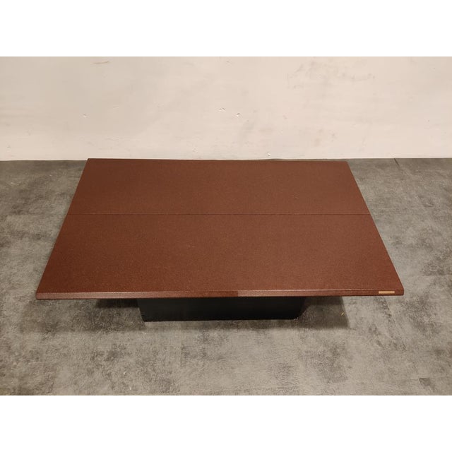 Eye catching coffee table with a hidden bar compartment. The table consists of two red/bordeaux coloured wooden table tops...