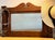 A handsome antique hall mirror crafted in richly figured tiger oak, with a broad beveled mirror and four ornate cast-metal...