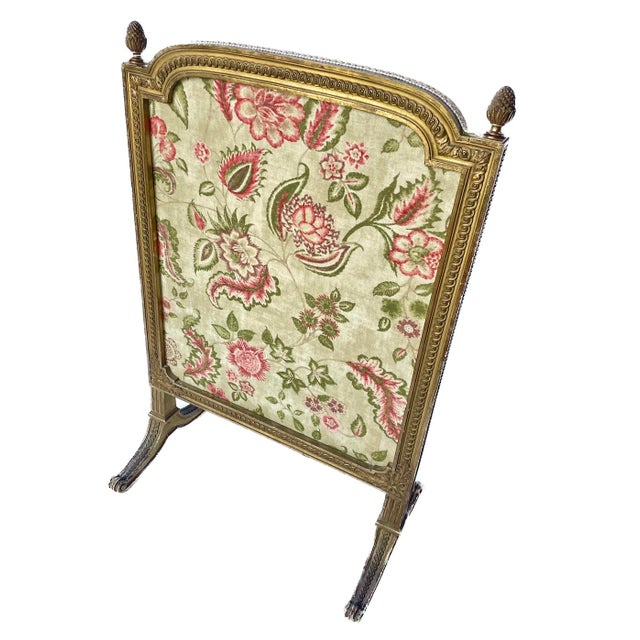 Antique giltwood floral linen upholstered fireplace screen with carved pine cone knob accents. Handcarved frame with...